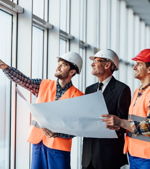 architect-man-showing-something-project-his-colleague-foreman